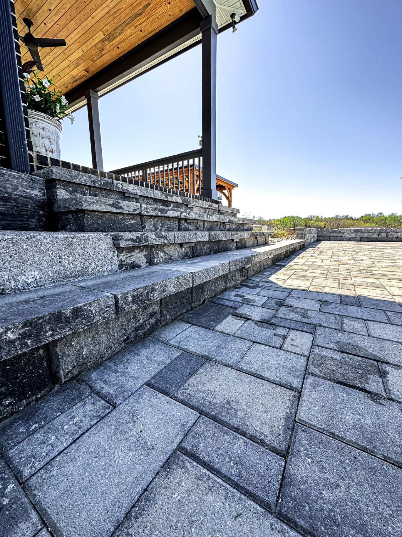Premium paver patio with stone steps and covered outdoor living area at luxury Tennessee property by Prestige Landscape